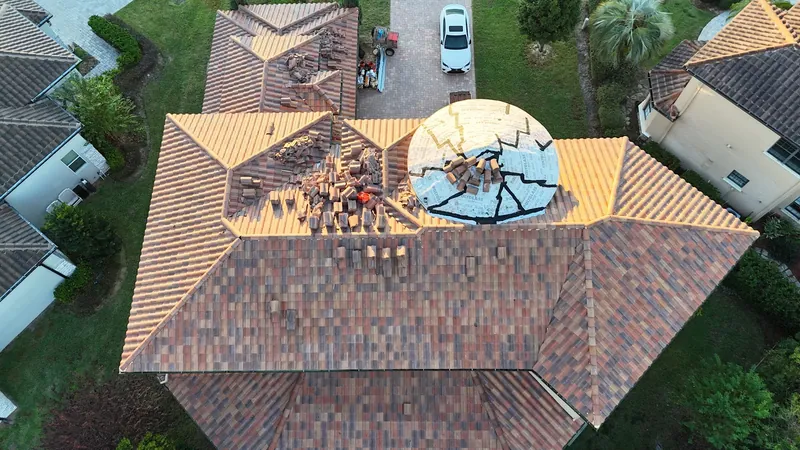 Barrel tile roof repair in progress, tiles lifted around a turret with the underlayment sealed beneath