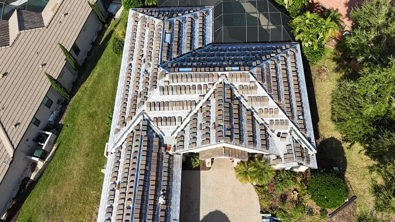 Tile roof installation with new tiles staged in rows across fresh underlayment